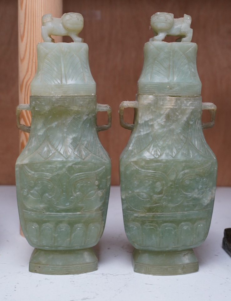 A pair of Chinese carved green quartz vases and covers, 21cm. Condition - fair, natural crack to body of one vase, chips to edges of both